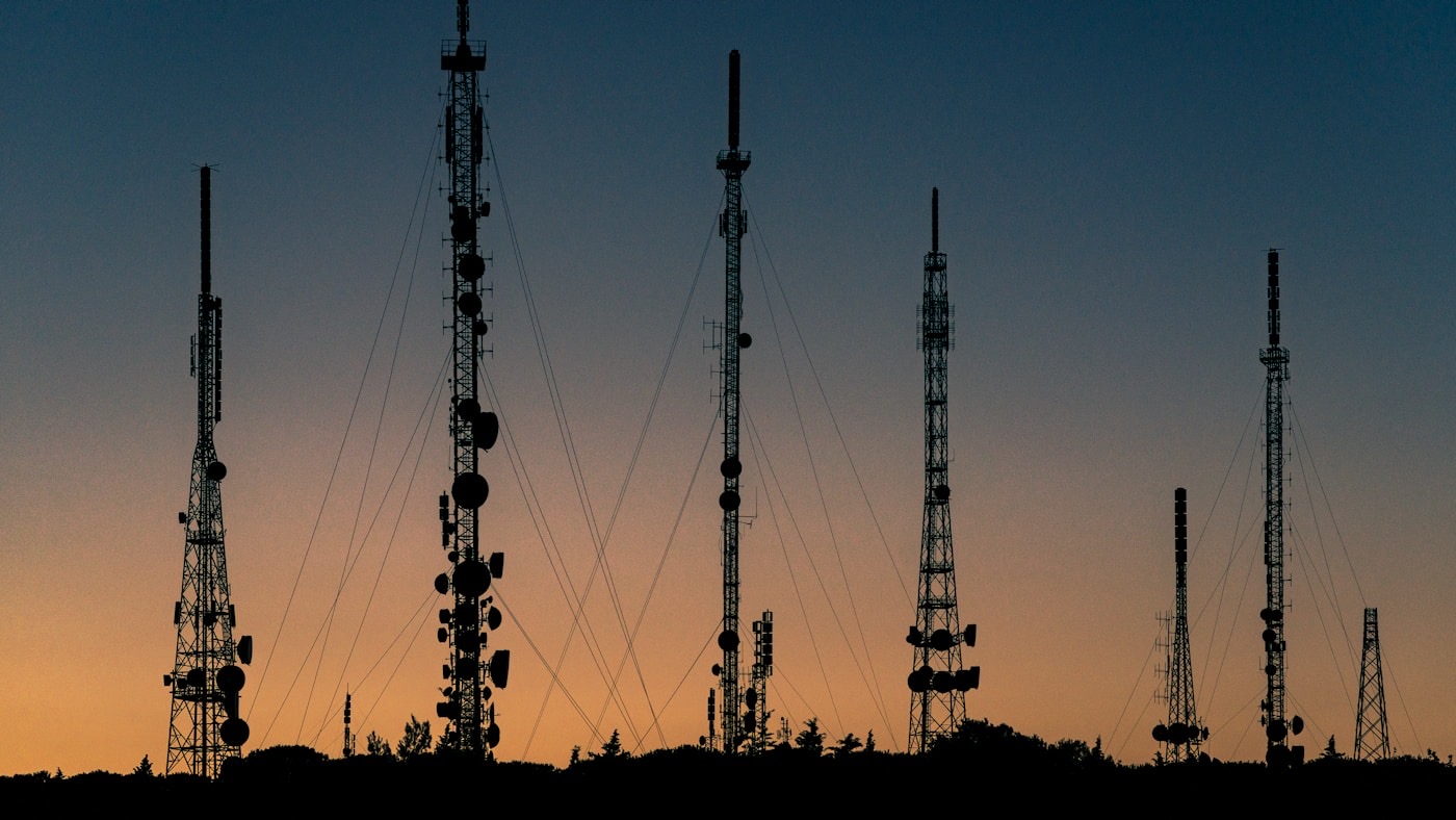 Silhouetted radio transmission masts against a dusk sky